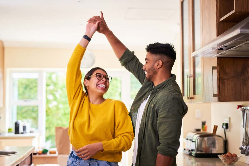 A man and woman smiling and dancing