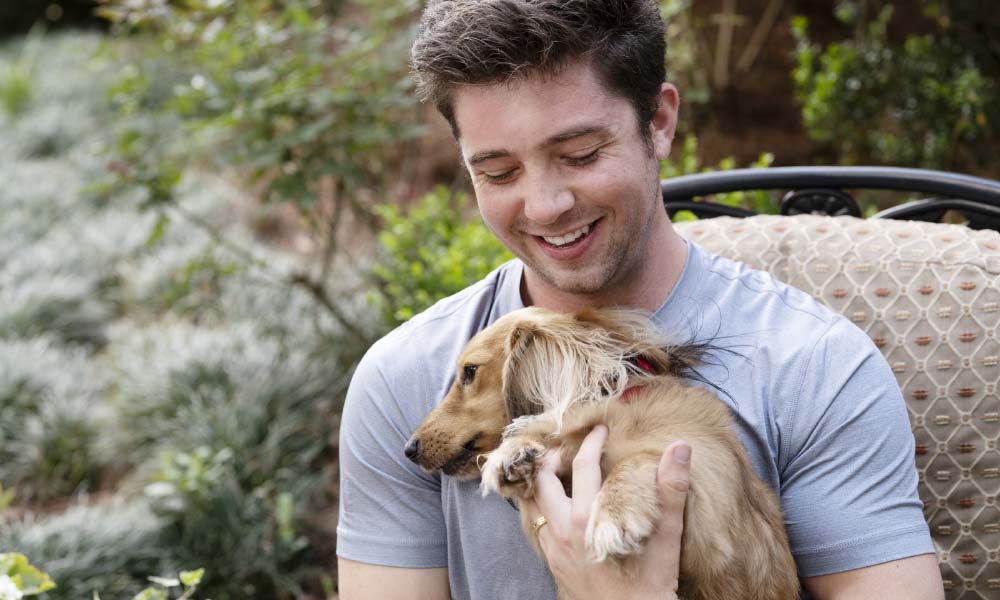 Freeman smiling while holding dog