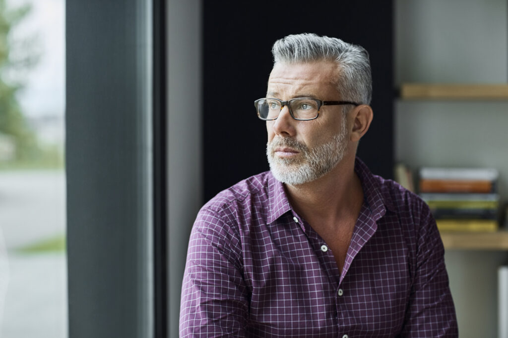 Thoughtful man looking out window